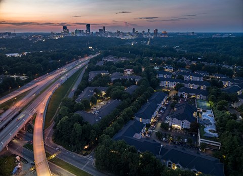 A cityscape at dusk with a highway running through it.
