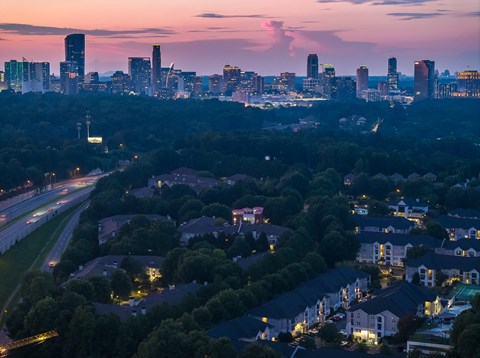 A cityscape at dusk with a mix of residential and commercial buildings.