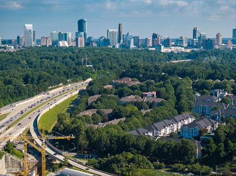 A cityscape with a highway running through a residential area.