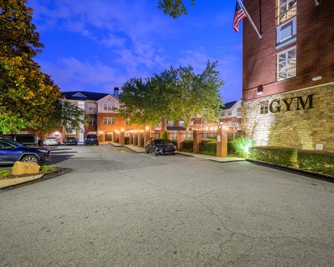 A gym is located in a parking lot with a brick building.