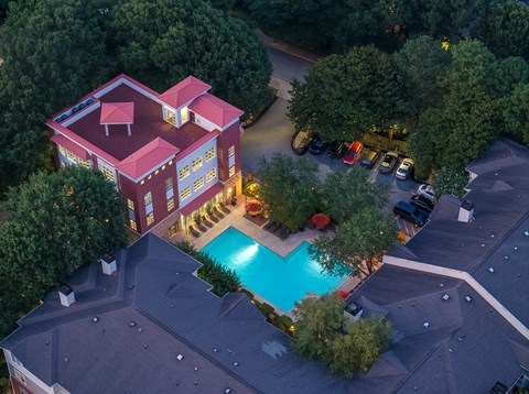 A red house with a pool in the backyard.