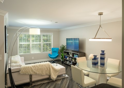 A modern living room with a glass table and a blue chair.