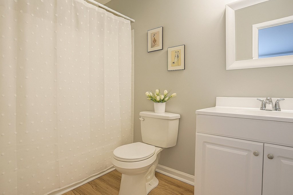 A white toilet sits in a bathroom next to a sink.