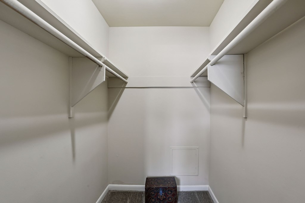 A small room with a bench and a vent in the floor.