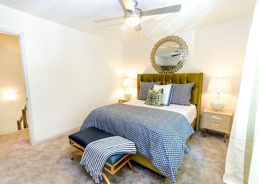 a bedroom with a bed and a ceiling fan
