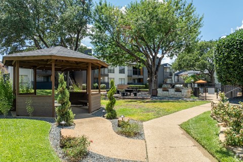 a gazebo in a park with trees and a building in the background at District 2308, Texas ?