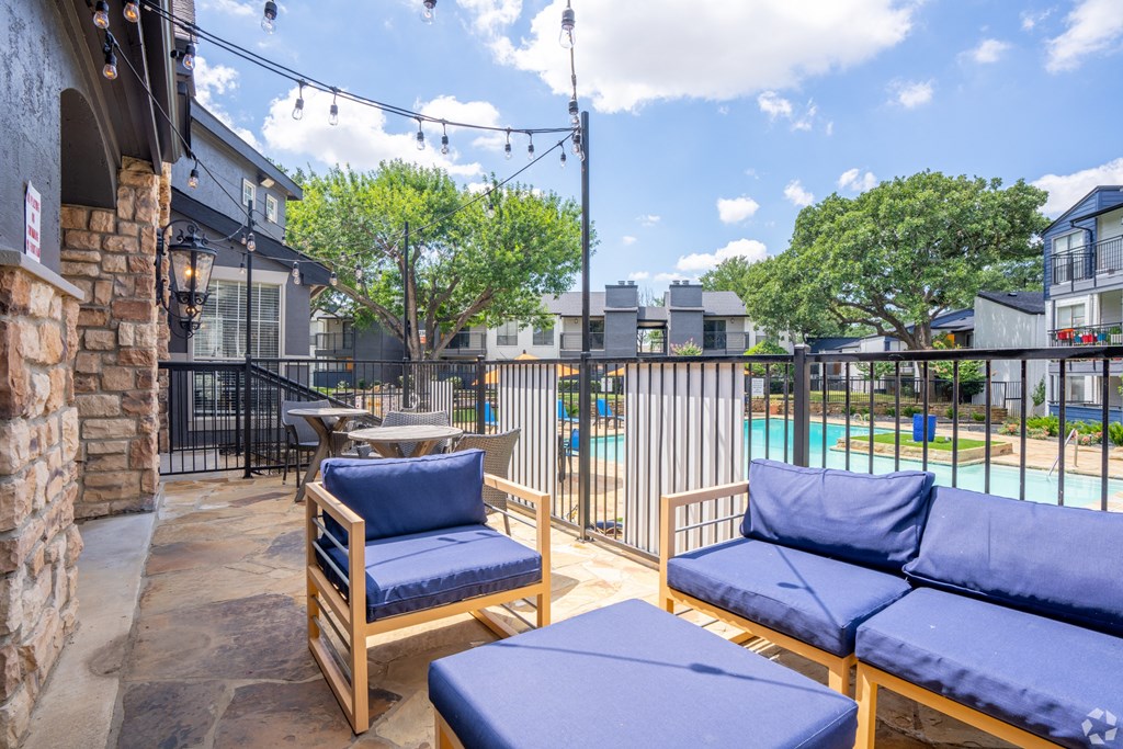 a patio with couches and chairs and a pool at District 2308, Texas, 76011