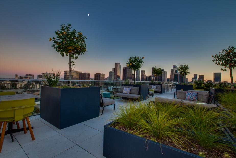 a rendering of a rooftop patio with city skyline in the background