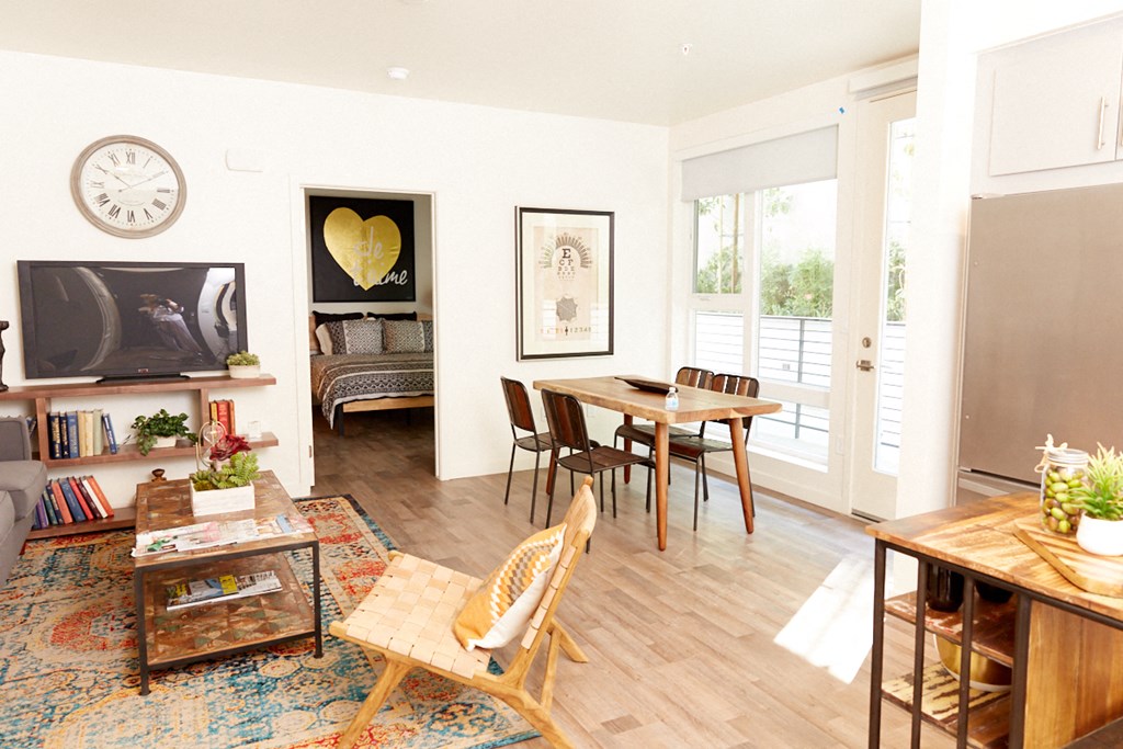 a living room and dining room with a table and chairs