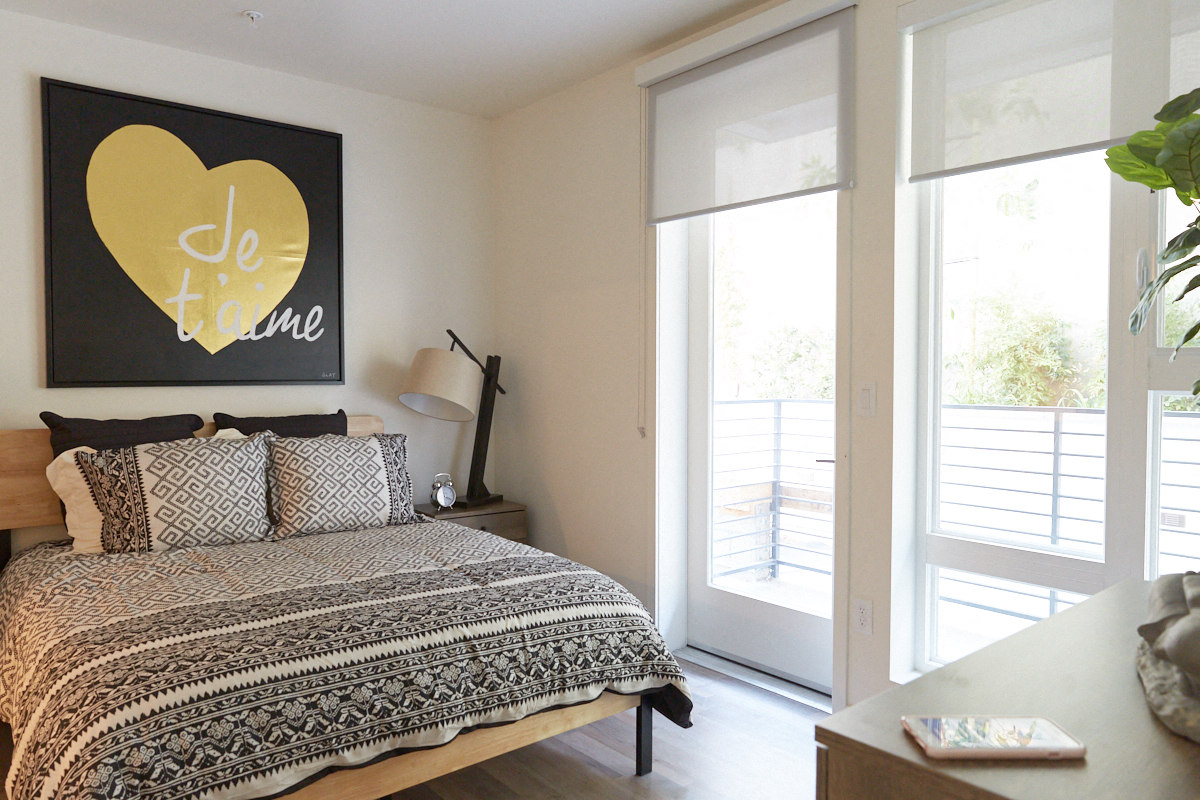a bedroom with a bed and a painting on the wall