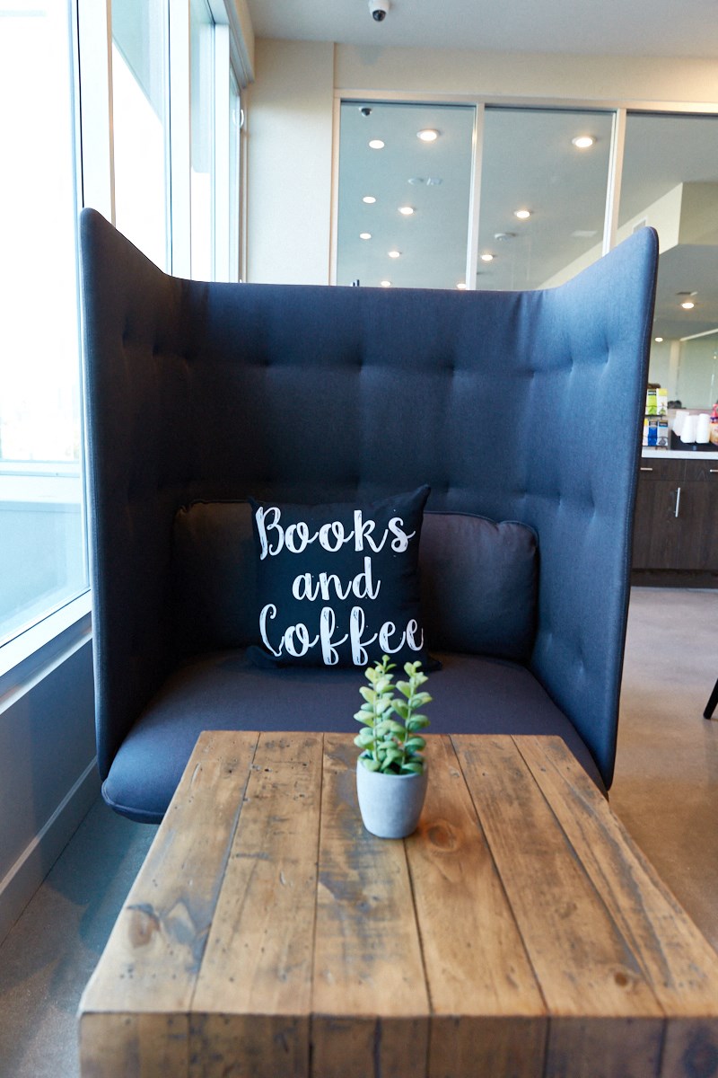 a wooden table in front of a blue couch with reads and coffee on it