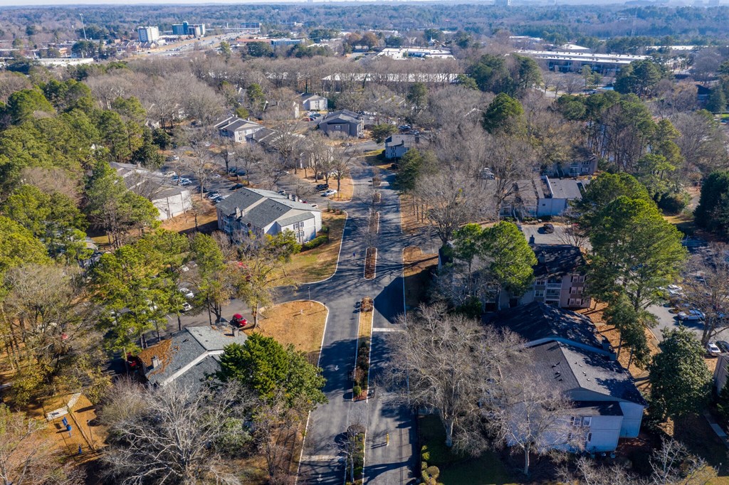 an aerial view of a neighborhood with trees and a train track