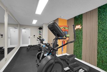 A row of exercise bikes are lined up in a room with a green wall.