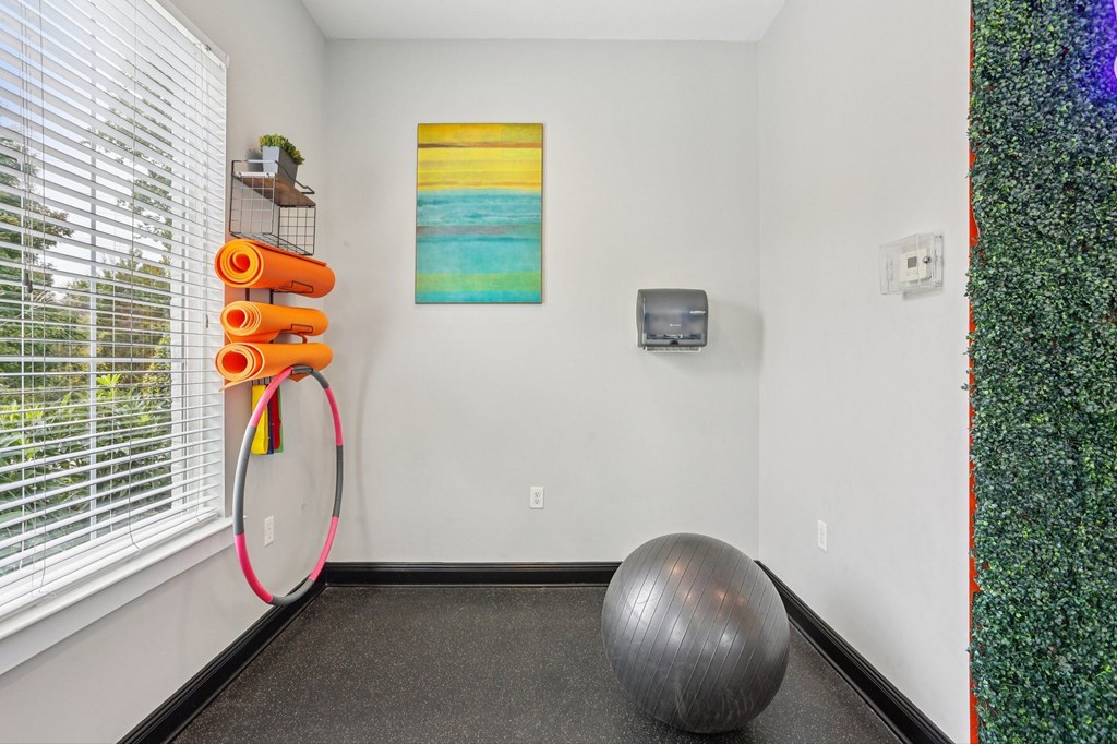 A room with a grey exercise ball and a hula hoop.