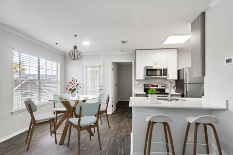 A modern kitchen with a dining table and chairs.