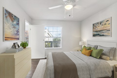 A bedroom with a large bed and a painting on the wall.
