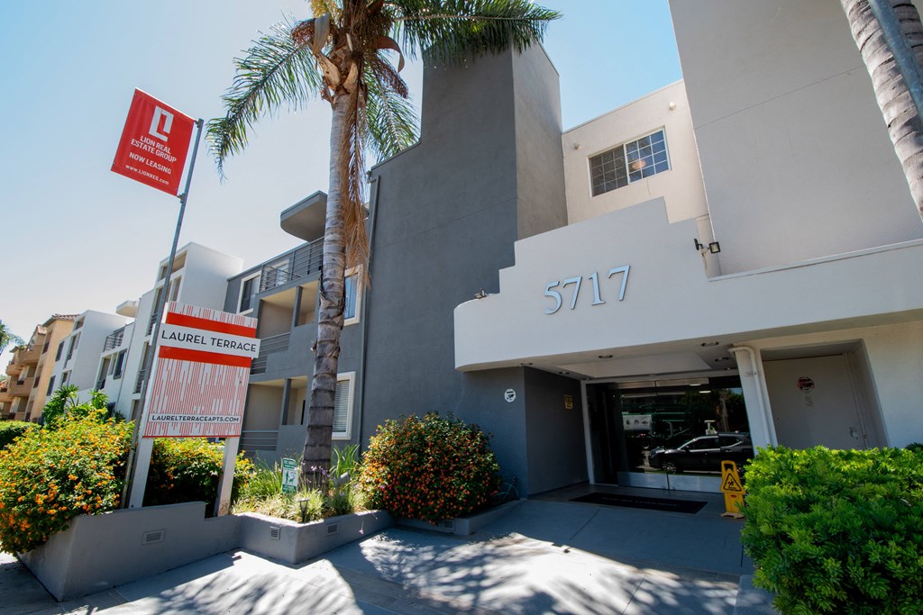 an apartment building with a palm tree in front of it