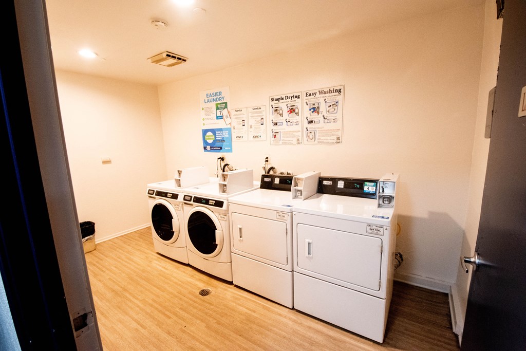 a laundry room with four washes and two dryers in it