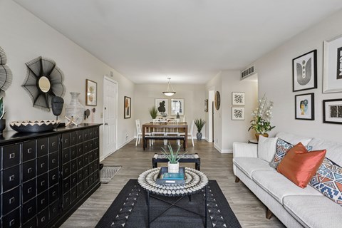 A living room with a white couch and a coffee table in the middle.