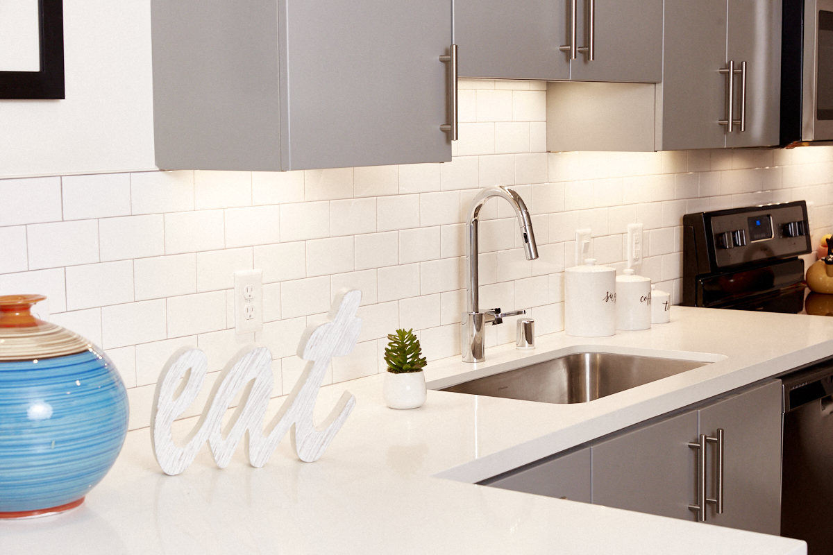 a white kitchen with a sink and a counter top