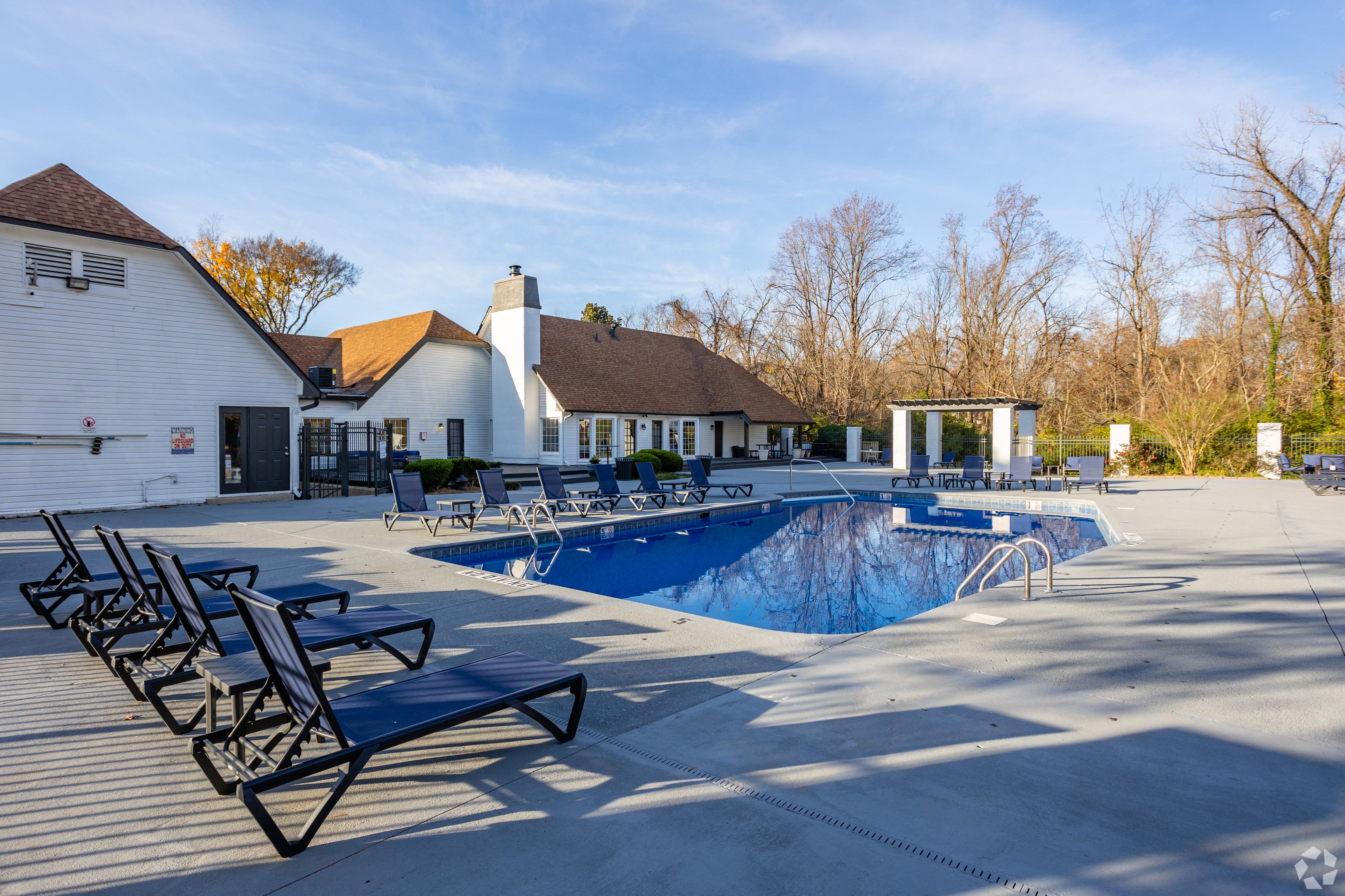 A pool with sun loungers and a white building in the background. at The Grove Brentwood, Nashville, TN 37211