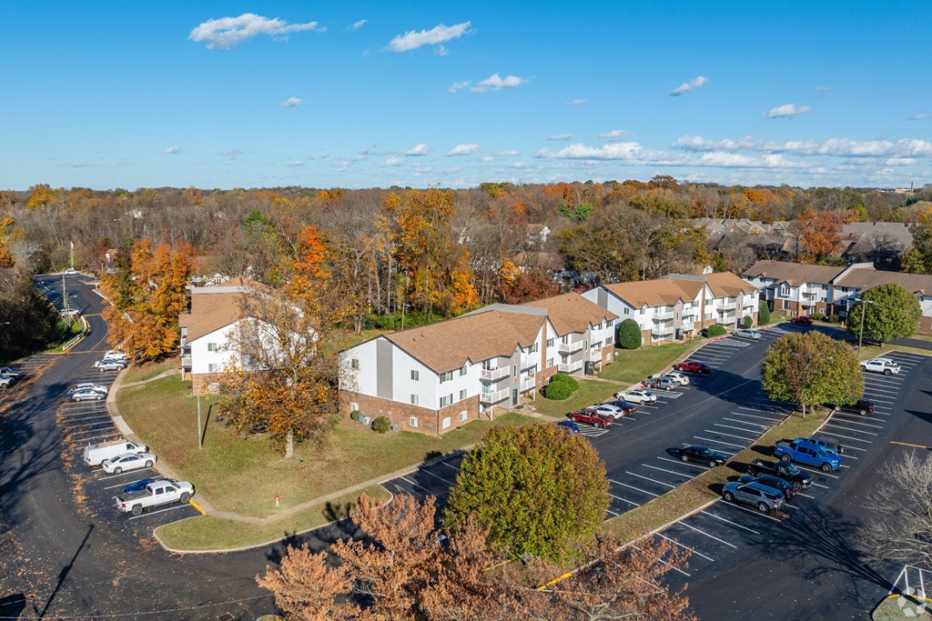 A parking lot with cars and apartment buildings in the background at The Grove Brentwood, Nashville, TN 37211 