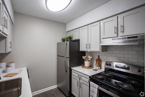A kitchen with a stove, refrigerator, and cabinets. at The Grove Brentwood, Nashville, TN 37211 