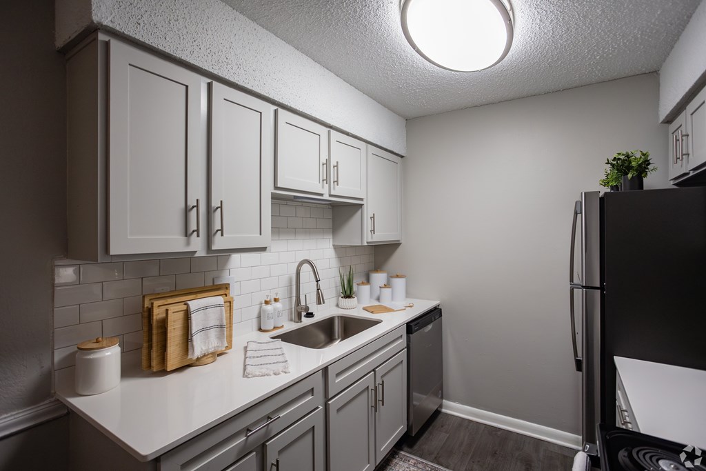 A kitchen with a black refrigerator and white cabinets. at The Grove Brentwood, Nashville, TN 37211 