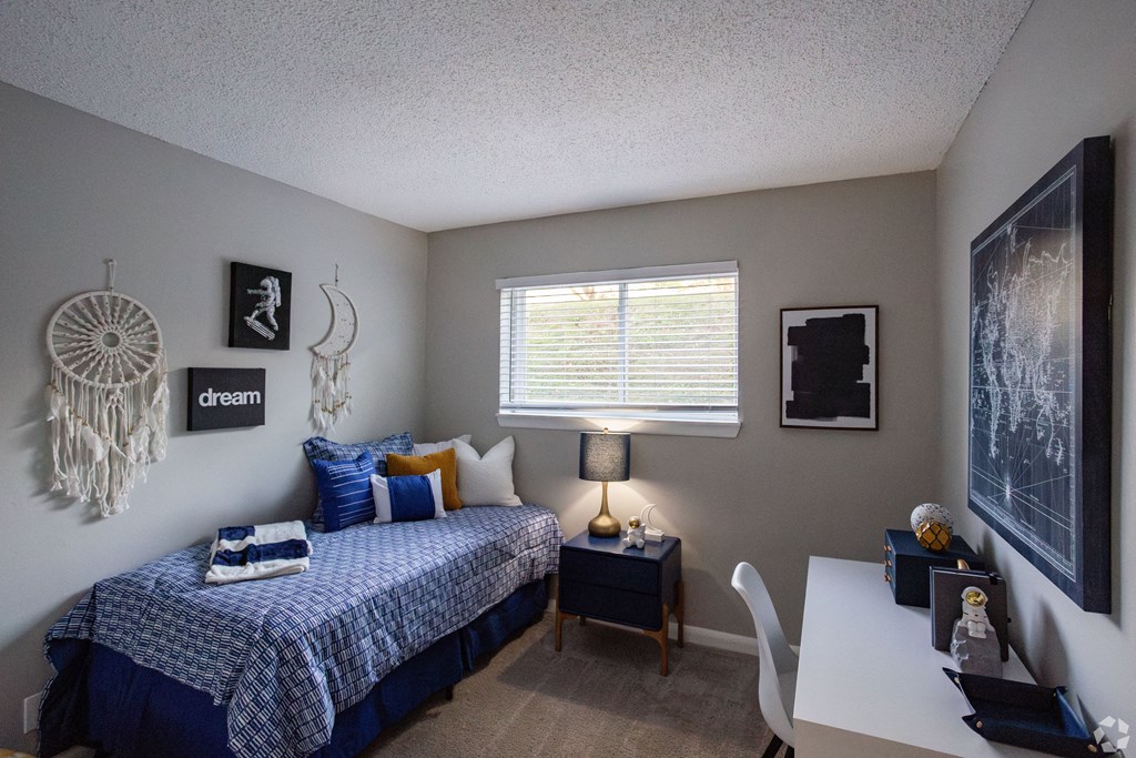 A bedroom with a bed, desk, and a dream catcher hanging on the wall. at The Grove Brentwood, Nashville, TN 37211 