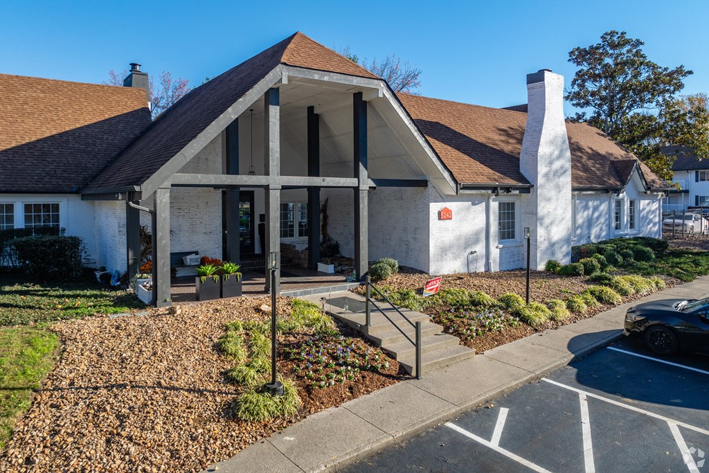 A white building with a brown roof and a black car parked in front. at The Grove Brentwood, Nashville, TN 37211 