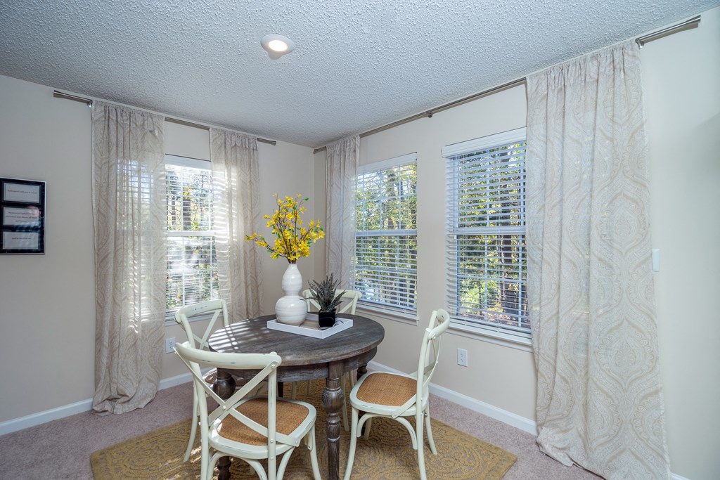 a dining room with a table and chairs and windows
