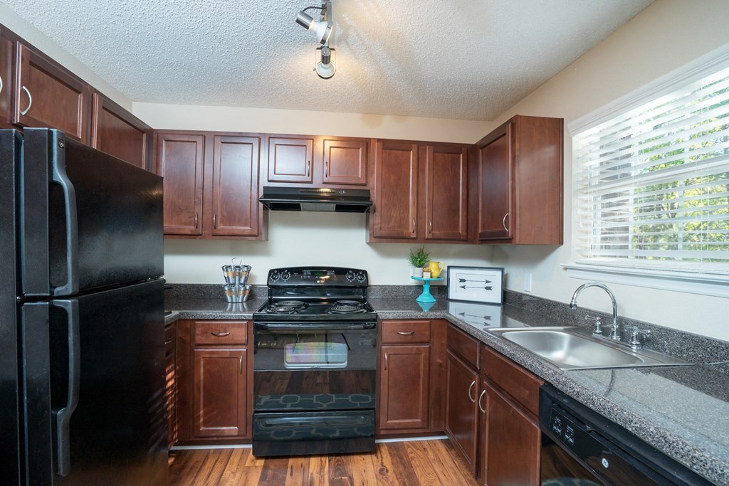 a kitchen with black appliances and wooden cabinets