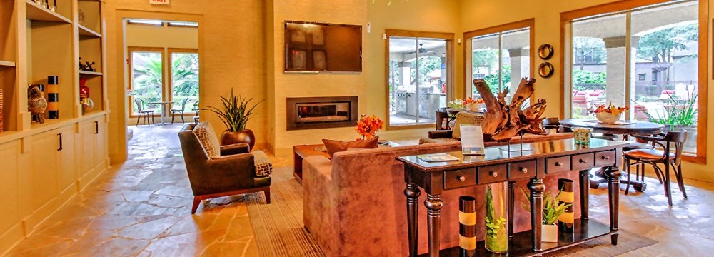 a living room with a couch and a table and a fireplace at Stone Creek at Old Farm Apartments, Houston, TX