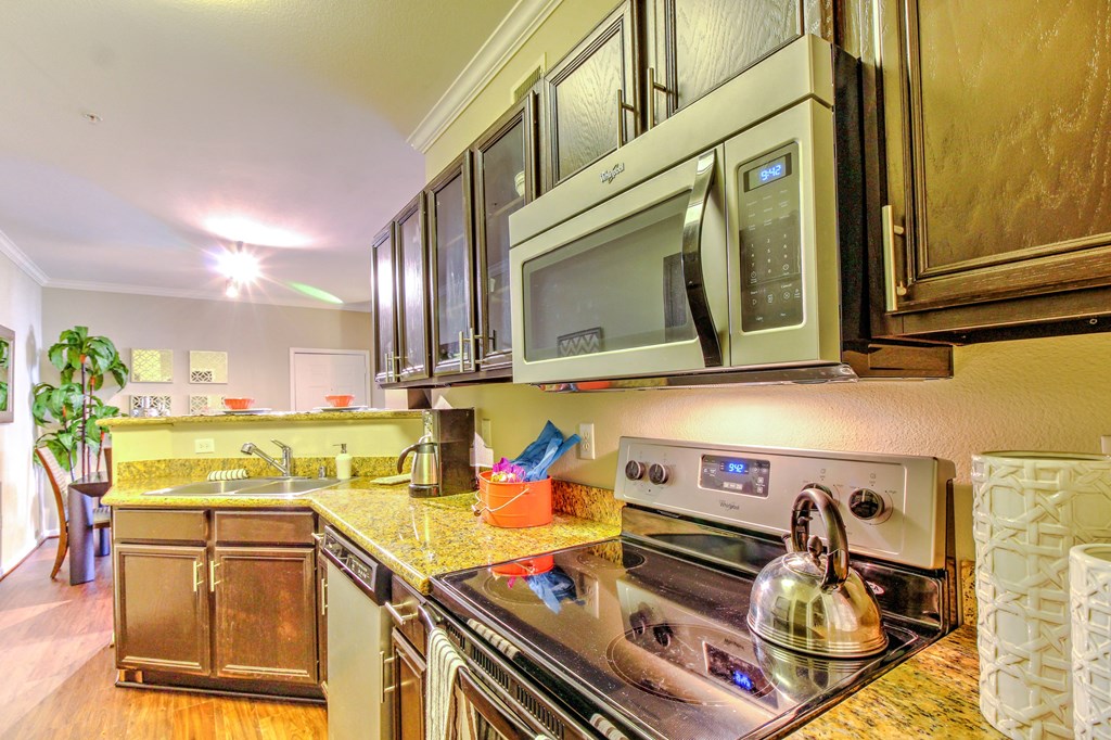 a kitchen with stainless steel appliances and a microwave at Stone Creek at Old Farm Apartments, Houston, Texas