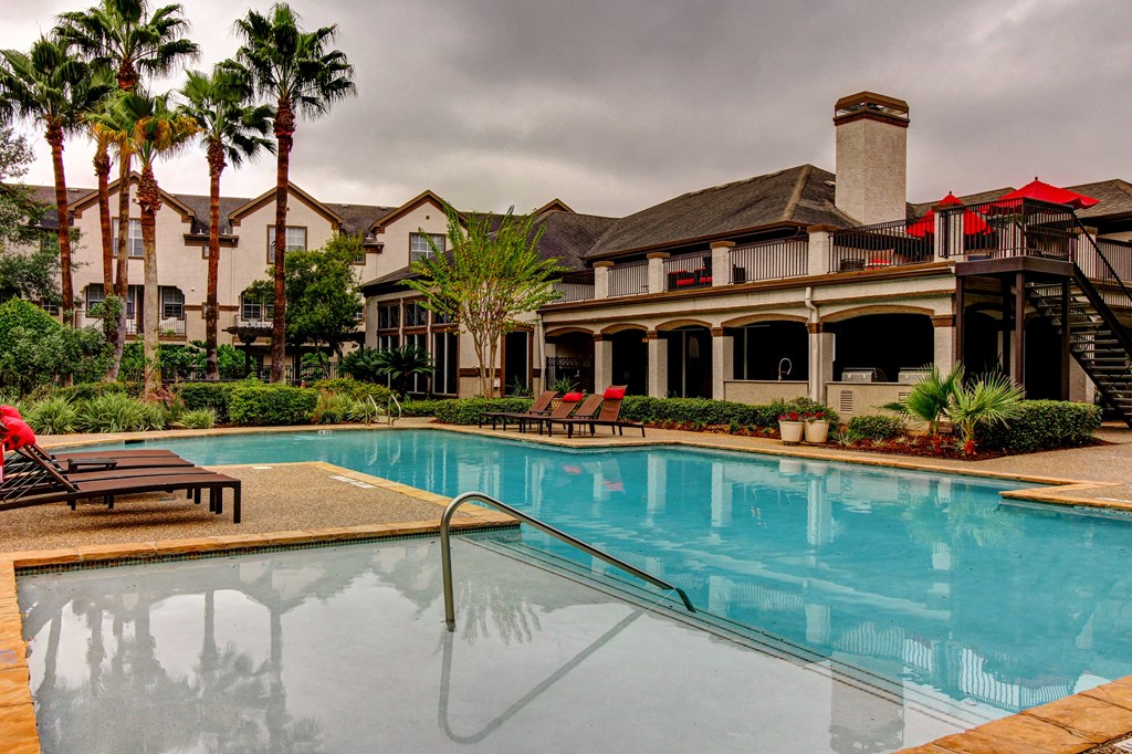 a swimming pool with a building in the background at Stone Creek at Old Farm Apartments, Houston, Texas