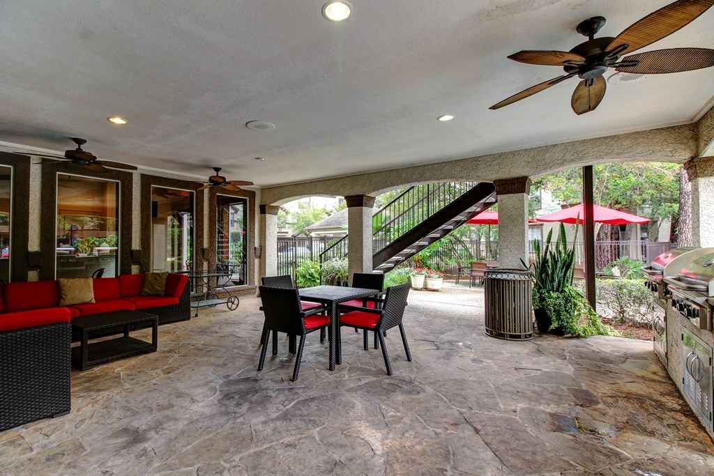 a patio with a table and chairs and a spiral staircase at Stone Creek at Old Farm Apartments, Houston, Texas
