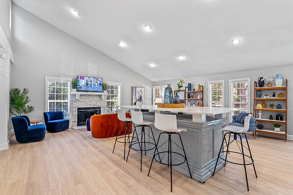 a living room with a fireplace and a bar with stools