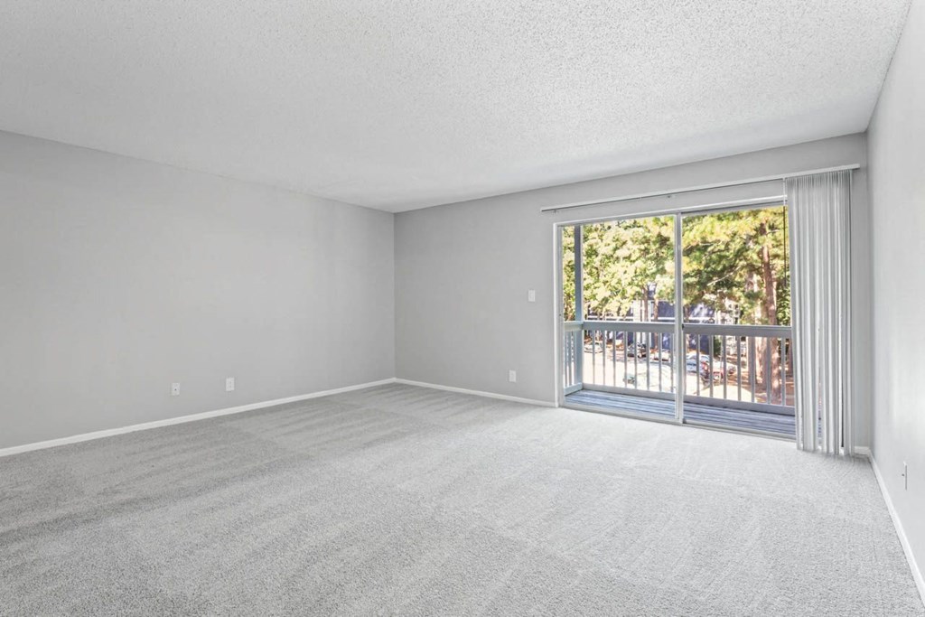 an empty bedroom with a sliding glass door and a balcony