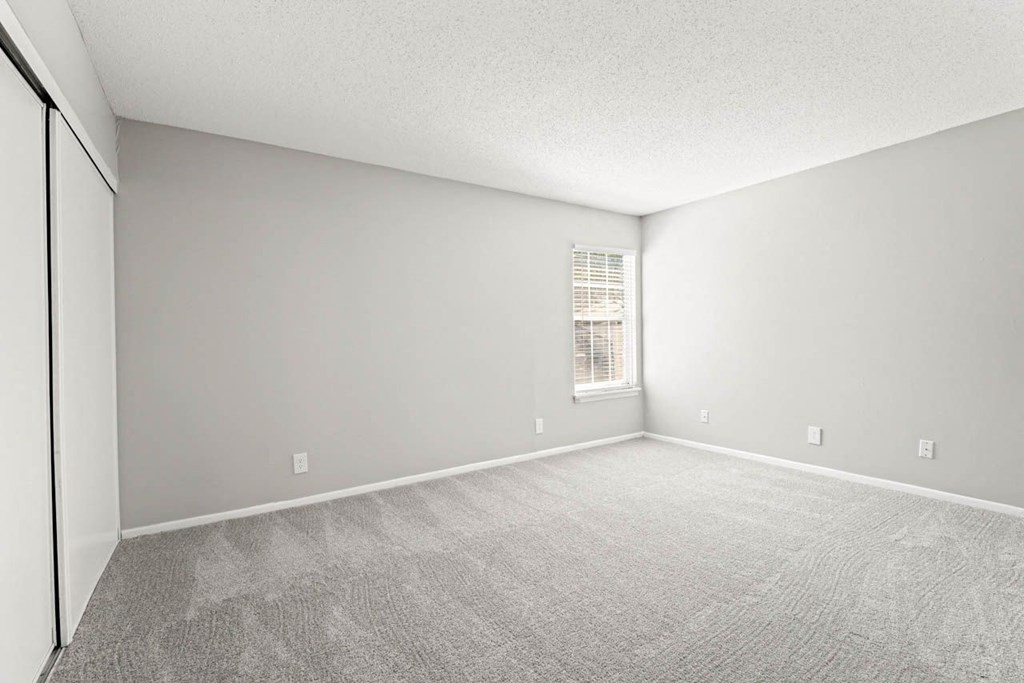 an empty bedroom with a window