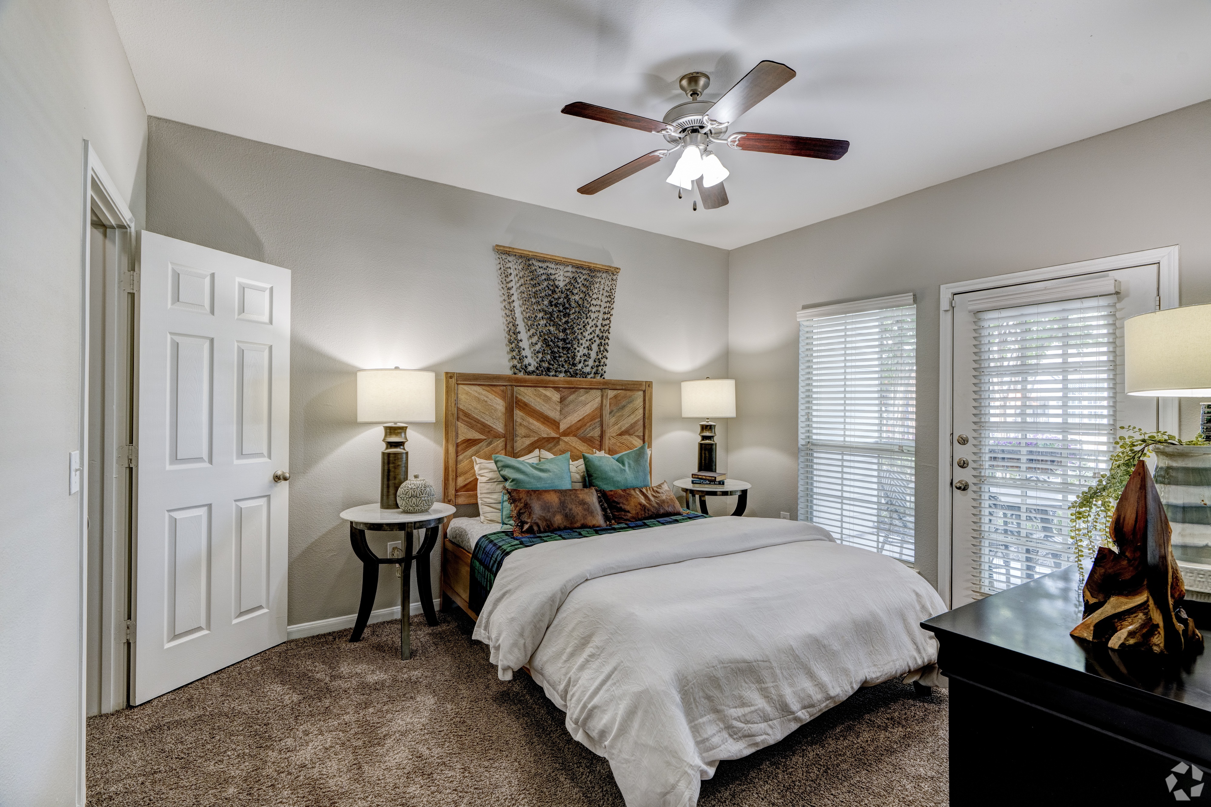 A bedroom with a large bed and a ceiling fan.