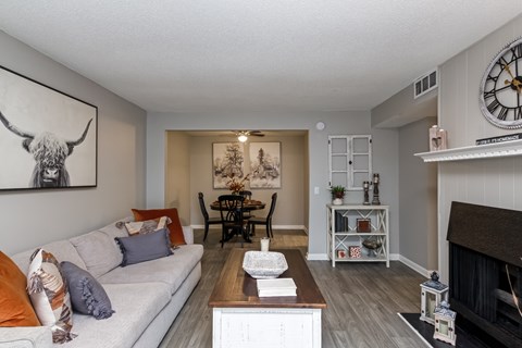 A living room with a couch, a fireplace, and a painting of a bull on the wall.