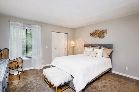 a bedroom with a large white bed and a window