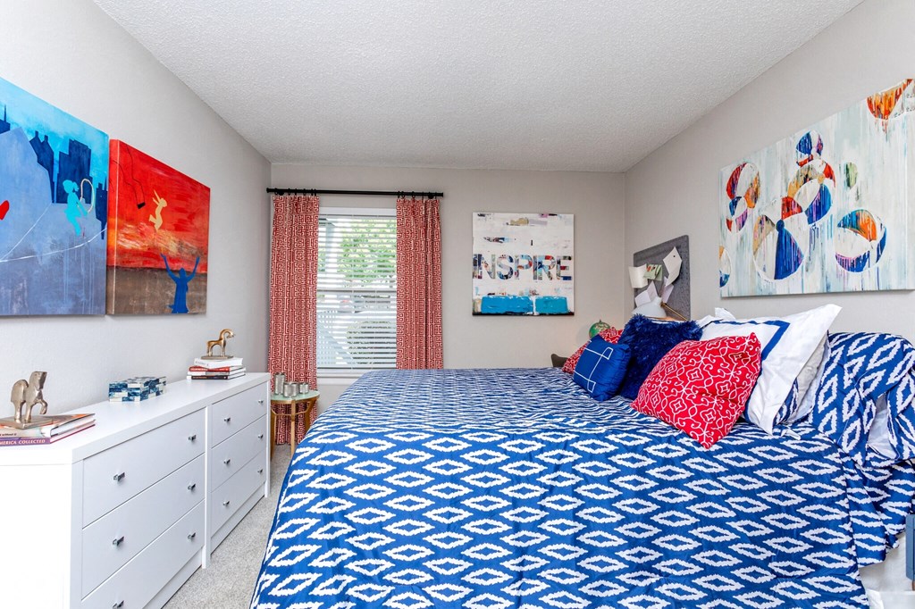 a bedroom with a bed and paintings on the wall