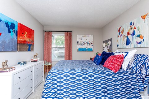 a bedroom with a bed and paintings on the wall