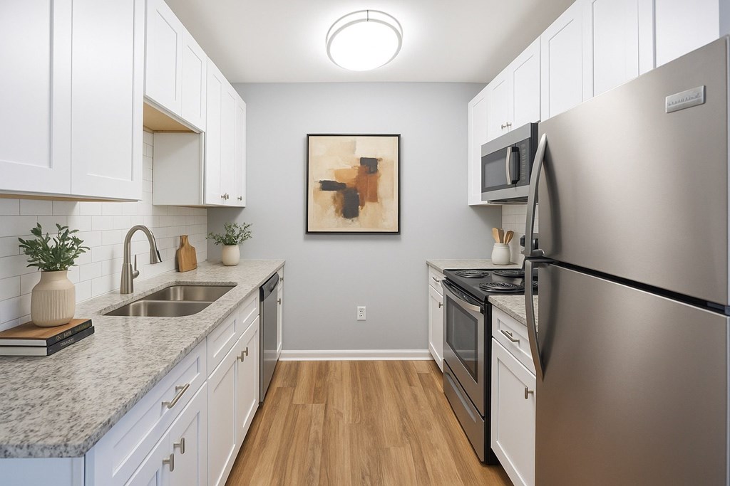 A kitchen with a refrigerator, sink, and oven.