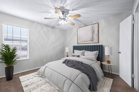 a bedroom with a bed and a ceiling fan