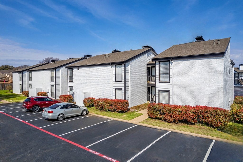a row of houses with cars parked in a parking lot at Keller Oaks, Carrollton, 75006 ?