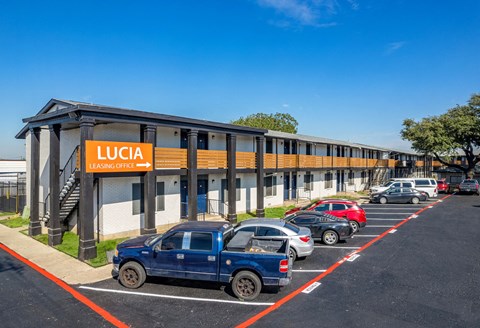 A Lucía Leasquat building with cars parked in front.