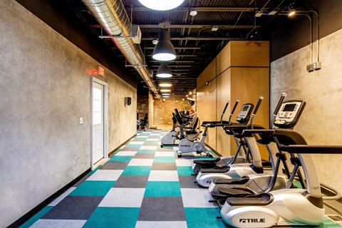 a gym with various exercise machines on a checkered floor