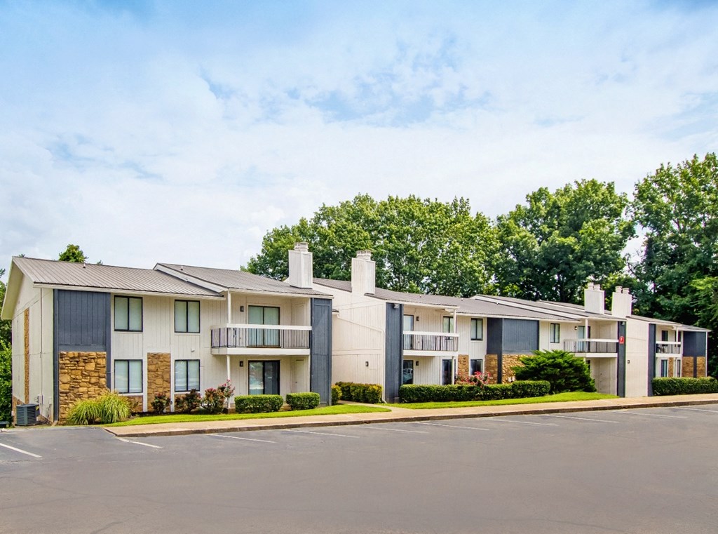 the view of an apartment building with a parking lot